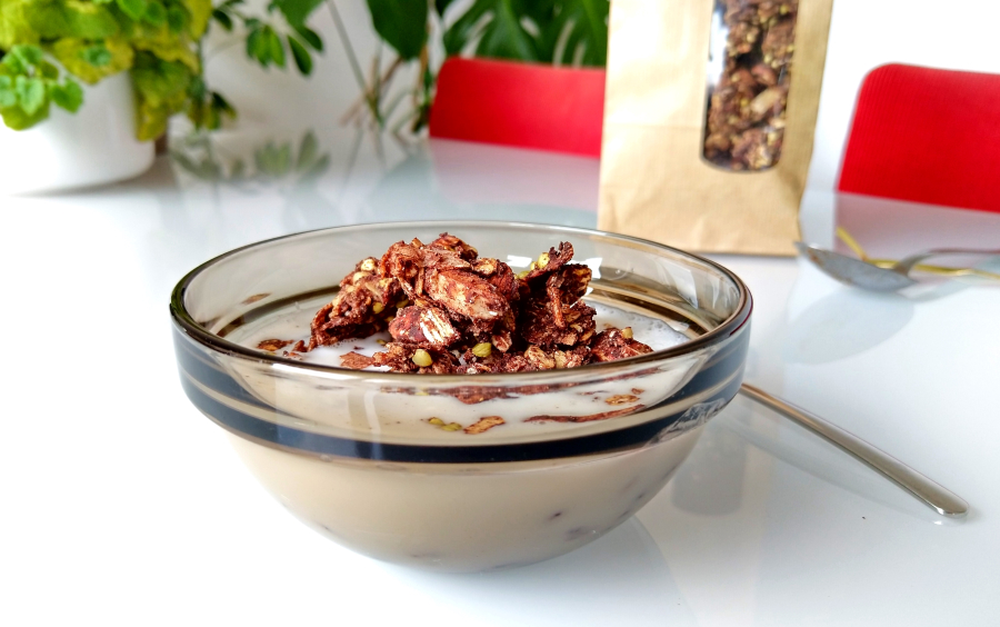 Boekweit-cacaogranola met kokoschips, geserveerd met amandelmelk