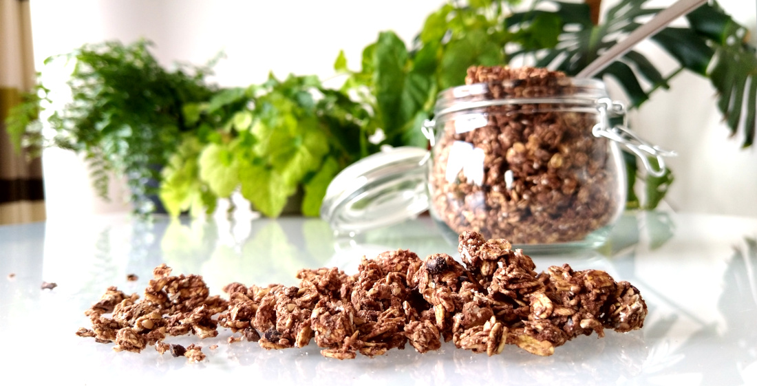 Zelfgemaakte chocoladegranola op tafel met pot met granola op de achtergrond